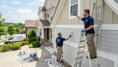 Professional house painters in Louisville KY applying fresh exterior paint to a residential home