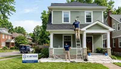 Professional house painters in Louisville KY applying exterior paint to a residential home façade